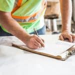 İnşaat sahasında proje planı hazırlayan mühendis ve çalışanlar.