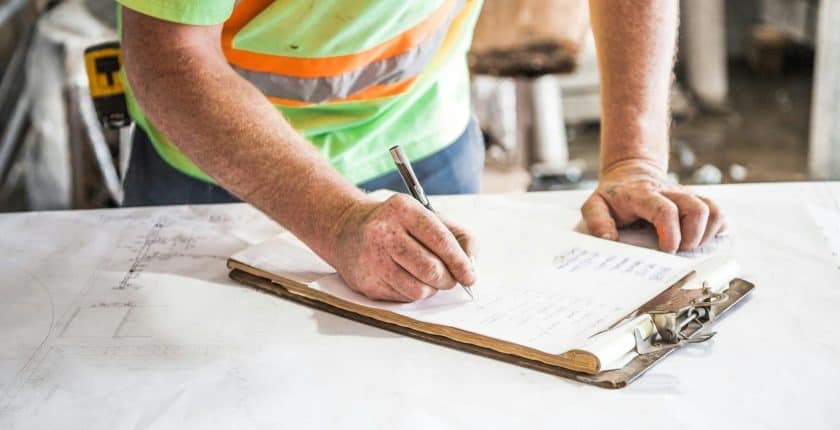 İnşaat sahasında proje planı hazırlayan mühendis ve çalışanlar.