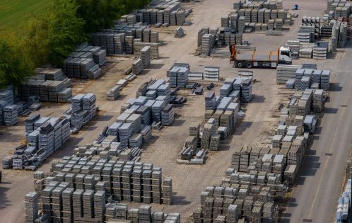 Aerial shot of a vast industrial yard with stacked bricks and a loading truck, captured on a clear day.